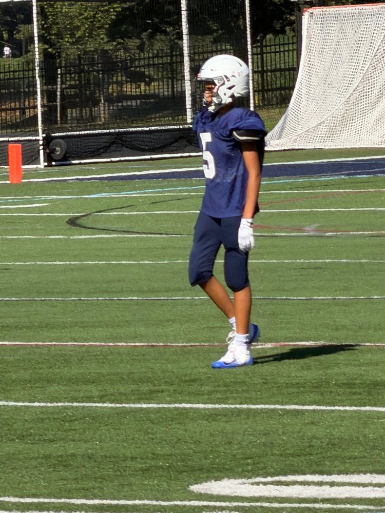 A young football player in a navy jersey on the field